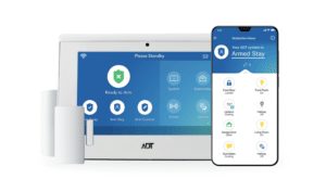 A phone displays a screen that says "Your ADT system is Armed Stay"