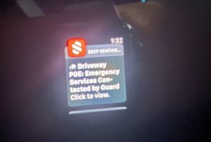 A person is wearing a smart watch that says "Driveway POE: Emergency Services Contacted"