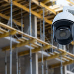 security CCTV camera or surveillance system with construction site on blurry background
