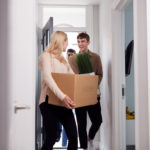 Group Of College Student Carrying Boxes Moving Into Accommodation Together