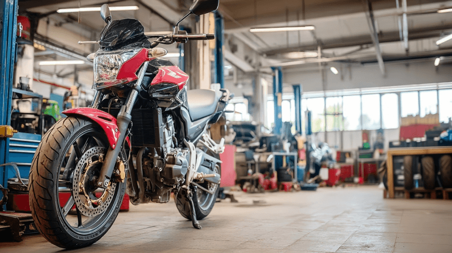 A red motorcycle parked inside a bright repair shop, surrounded by lifts, tools, and equipment. The space is clearly set up for powersports service,A red motorcycle parked inside a bright repair shop, surrounded by lifts, tools, and equipment. The space is clearly set up for powersports service.